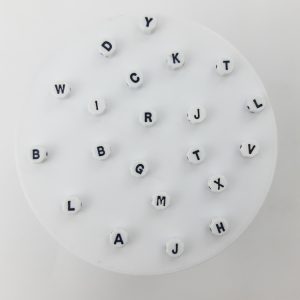 Pasante en forma de pastilla hexagonal con letras